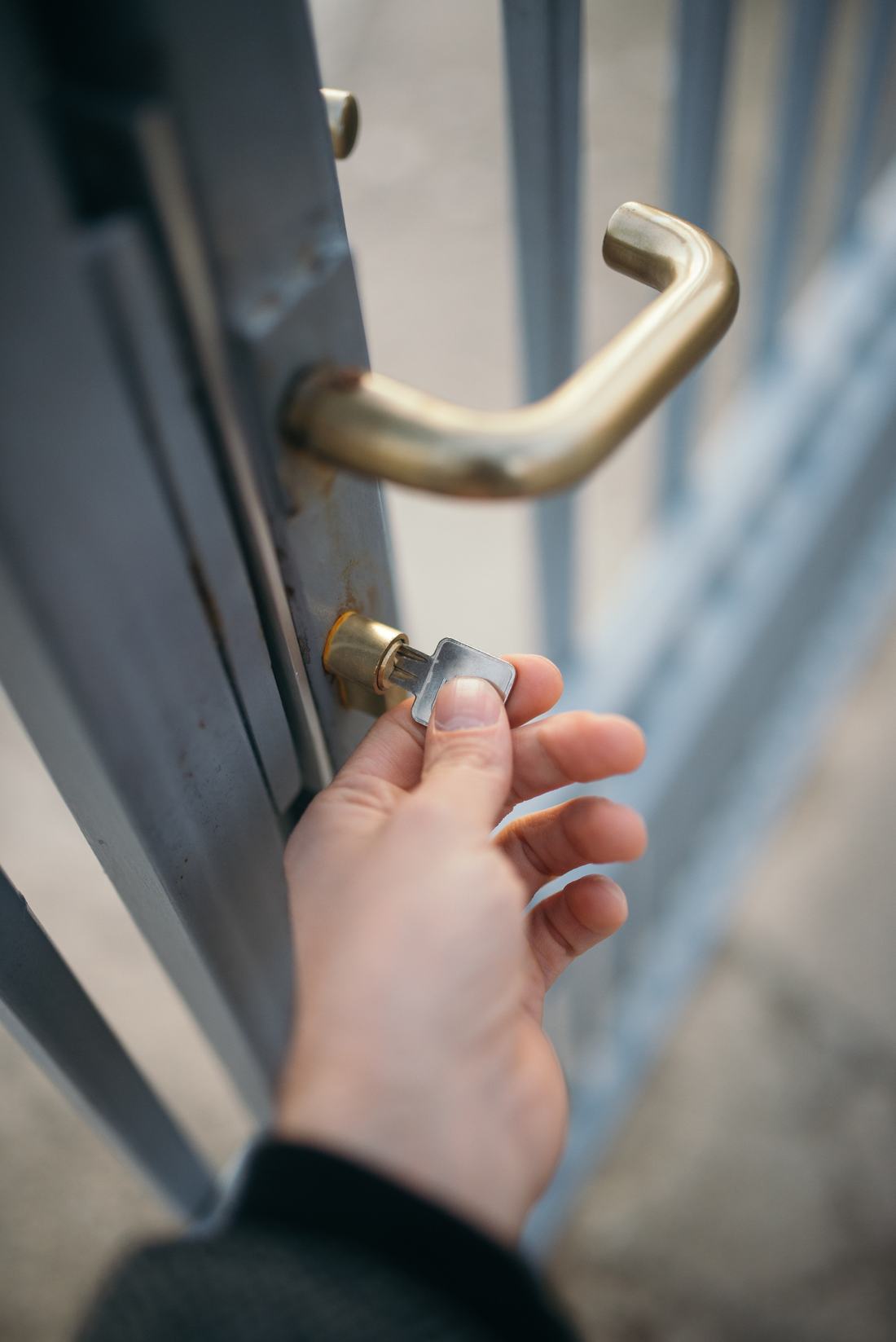 Hand, die einen Schlüssel ins Türschloss steckt